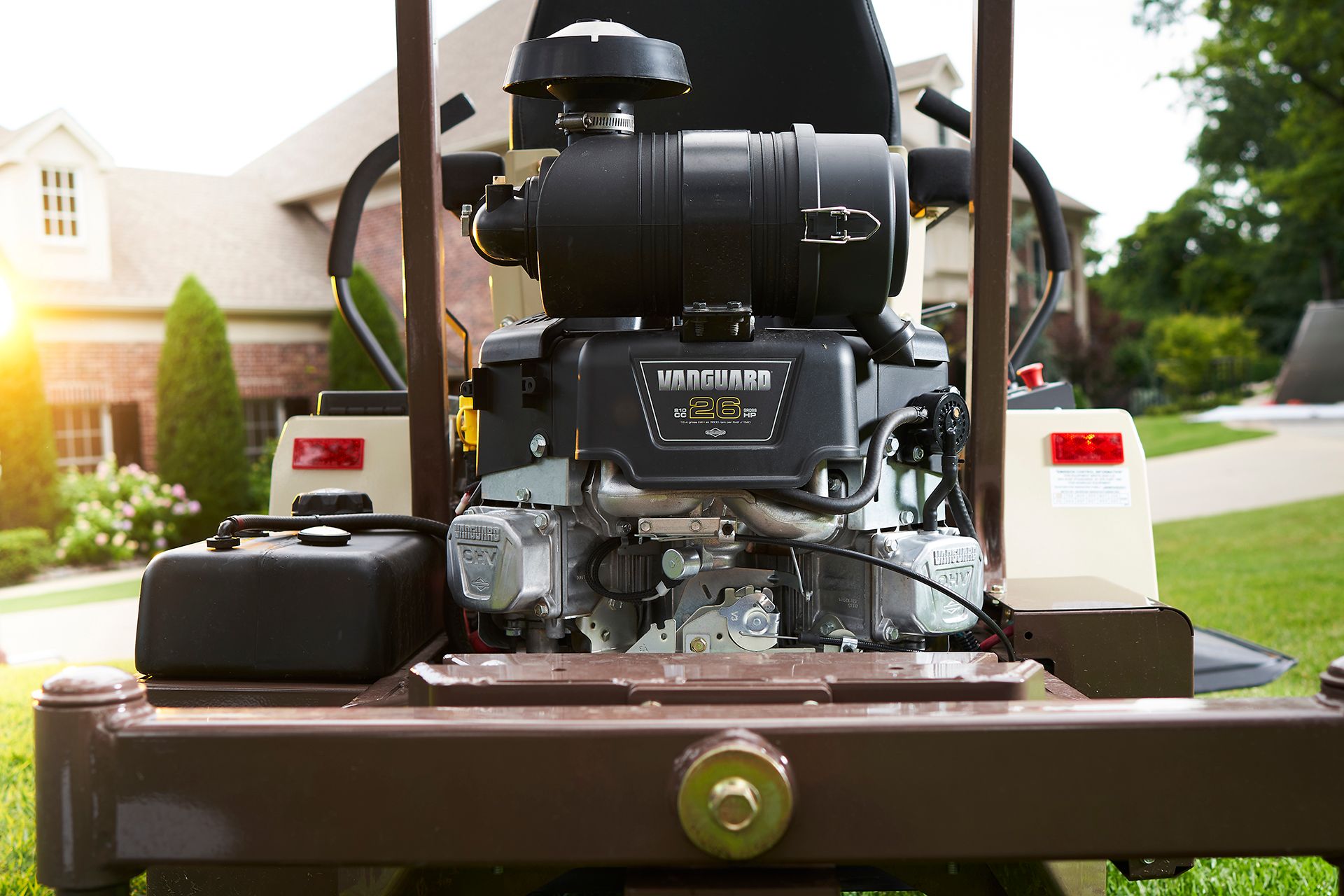 Close-up of a mower's exposed Vanguard 26 horsepower engine, air cleaner, and rear tail lights.