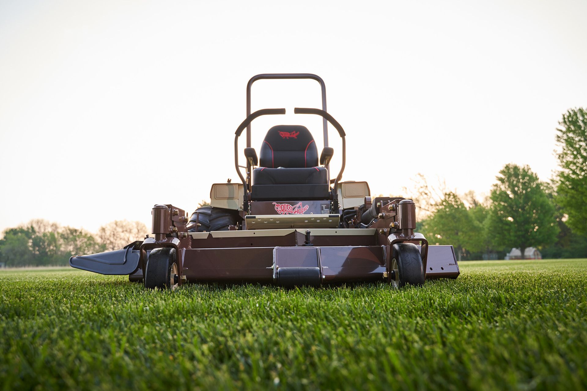 Head-on view of a Grasshopper FrontMount mower and its discharge chute on thick turf.