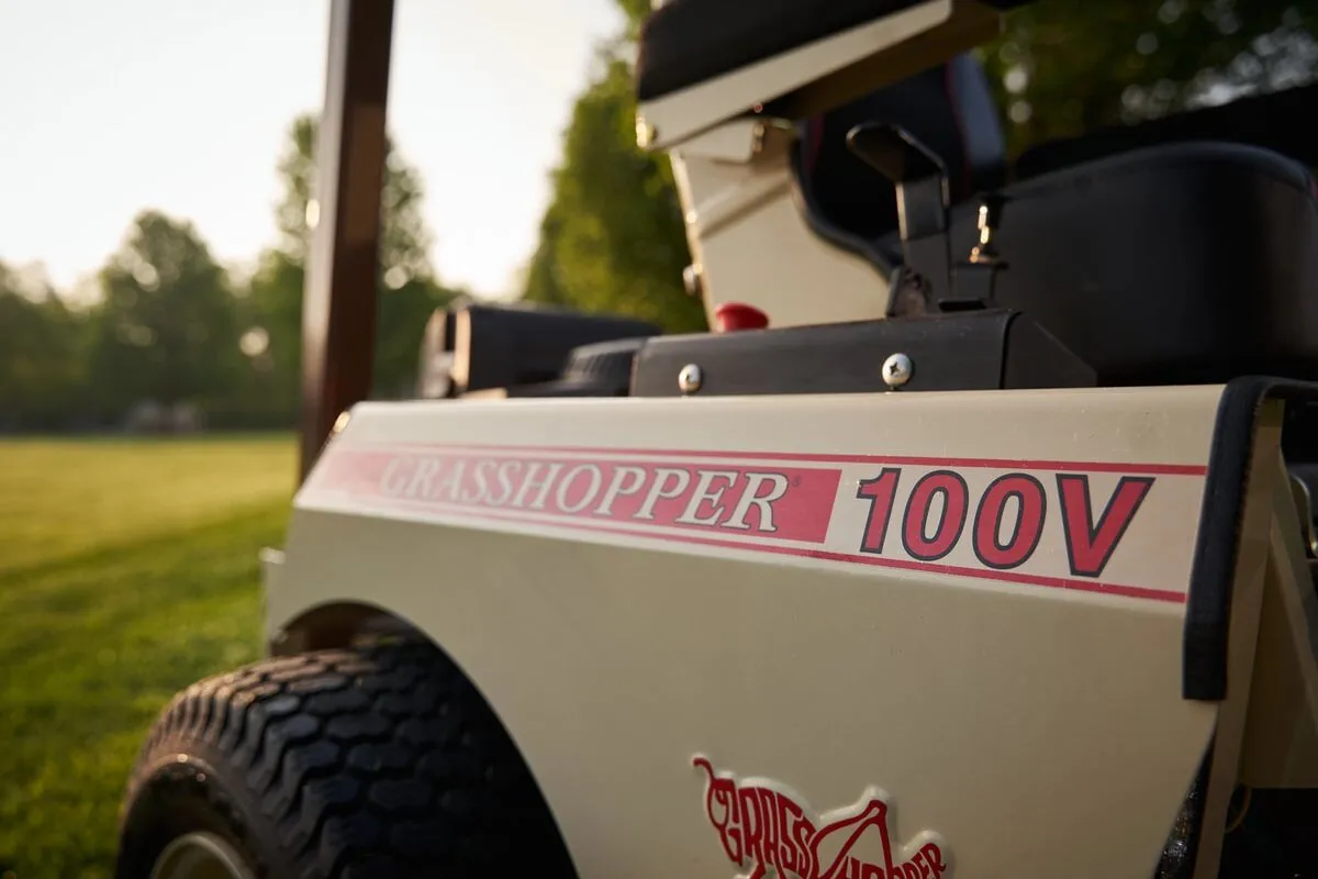 Close-up of the Grasshopper 100V decal on a mower's cream side panel.