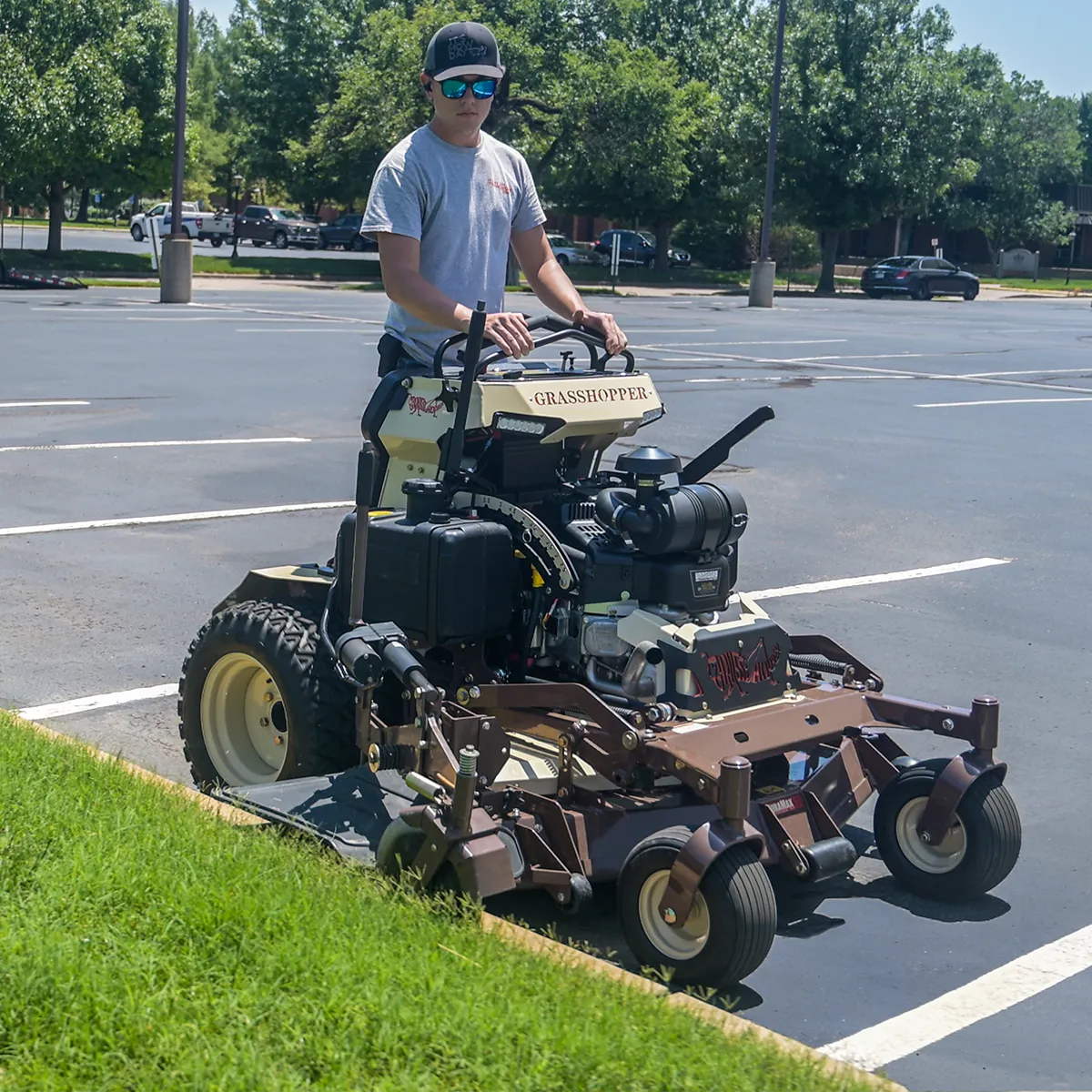 Stand-On Commercial Zero-turn lawn mower using an edger mower attachment for precise trimming.