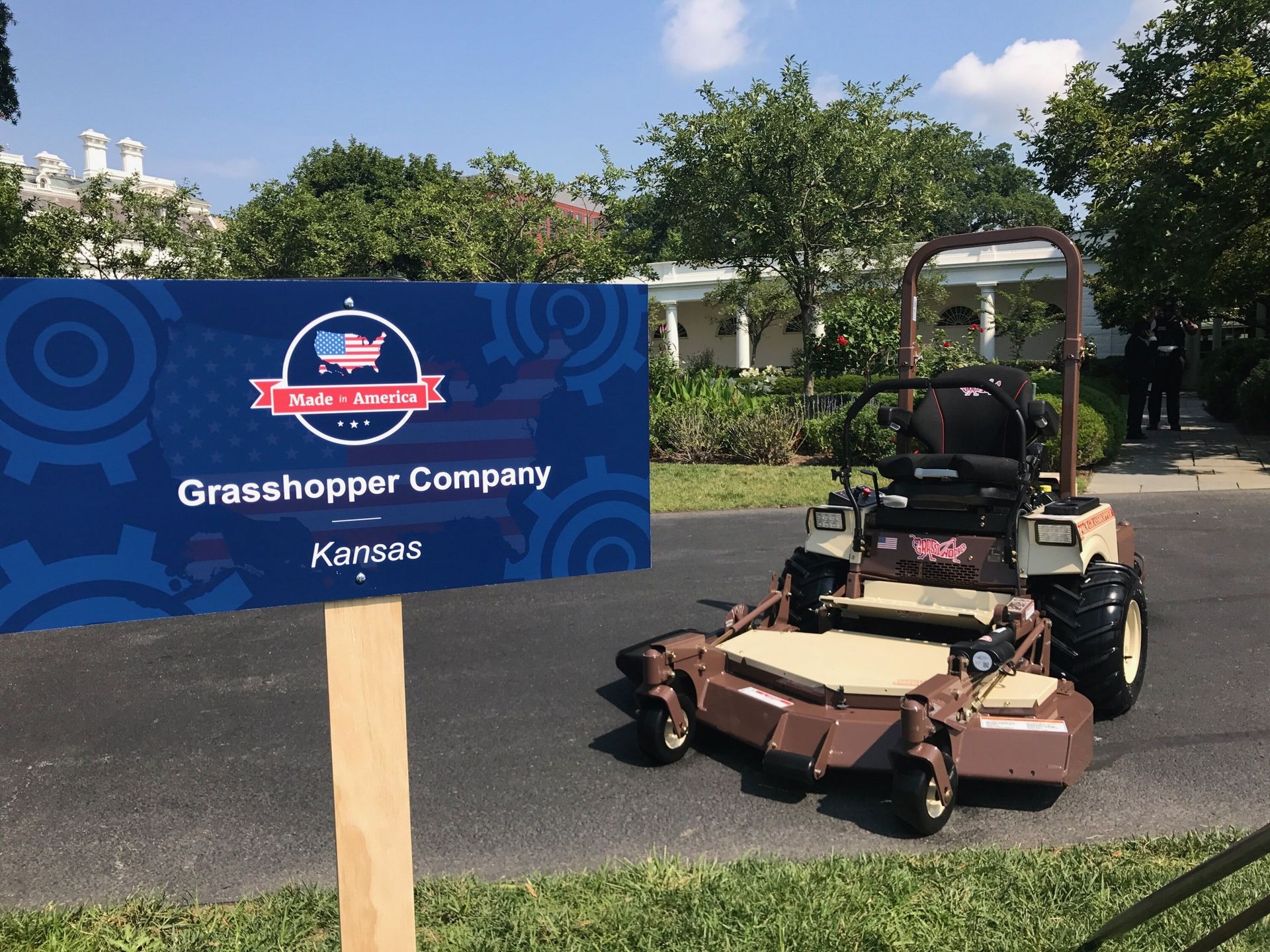 Grasshopper FrontMount mower beside a Made in America sign on the White House grounds.