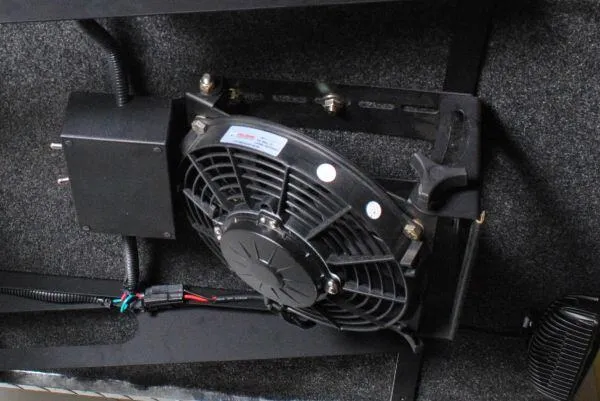 Black electric canopy fan in a wire guard, bracket-mounted with its wiring harness attached.