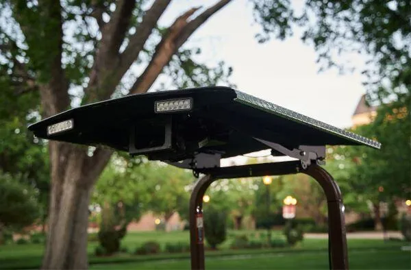 Black sunshade canopy fitted with LED light bars mounted atop a mower's rollbar.
